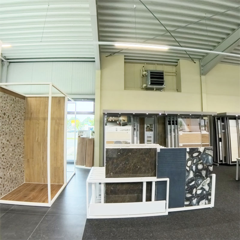 Innenansicht von unserer Fliesenausstellung in Delmenhorst. Blick auf die Wandfliesen, im Vordergrund Marmoroptik Fliesen im Format 60x120cm